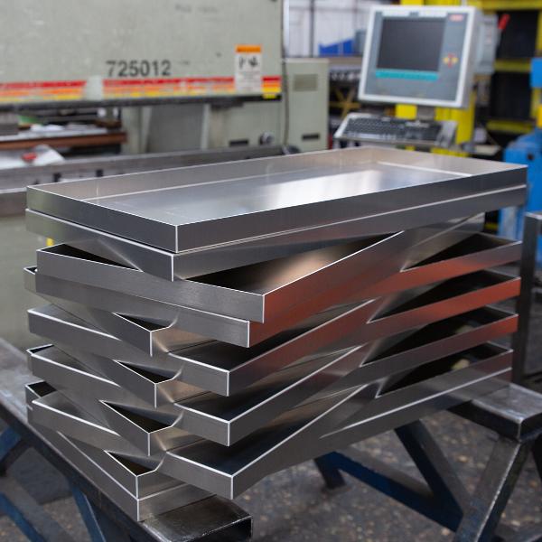 https://www.coremarkmetals.com/files/image/medium/Formed stainless steel metal pan stacked together