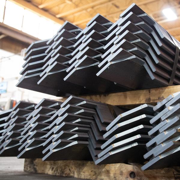 https://www.coremarkmetals.com/files/image/medium/Custom cut steel angles on pallet banded together